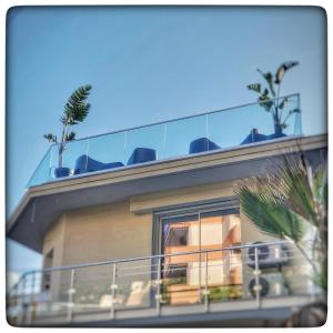 a building with a balcony with palm trees on it at Le Vallaya Suites & Spa in Menton