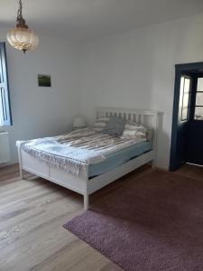 una camera con un letto bianco e un tappeto viola di Duba ház a Balaton-felvidéken a Tapolca