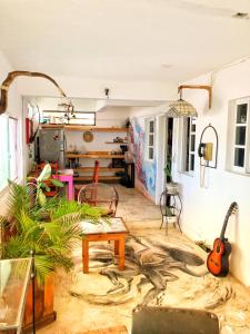 a living room with a table and a guitar at Mi Refugio Dive House in Cozumel