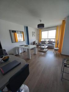 a living room with a couch and a table at magnifique appartement 3 étoiles centre ville et mer à pied in Saint-Brevin-les-Pins