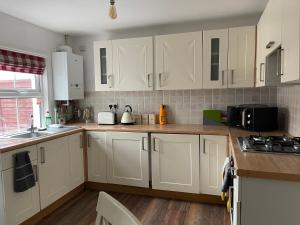 a kitchen with white cabinets and a counter top at April Cottage Ringwood in Ringwood