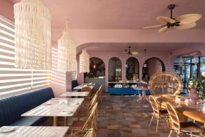 a restaurant with tables and chairs and a ceiling fan at Hotel Rocas de Bahía in Bahia Inglesa