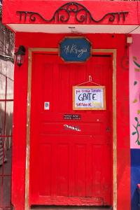 une porte rouge sur un bâtiment rouge avec un panneau sur celui-ci dans l'établissement Mi Refugio Dive House, à Cozumel