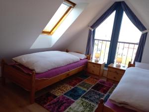 een slaapkamer op zolder met 2 bedden en 2 ramen bij Nordseemole in Horumersiel