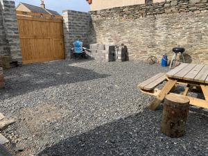 a wooden picnic table sitting next to a stone wall at Church view in Wick