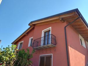 Edificio rosa con balcón y cielo azul en Villa Piscinas en Piscinas