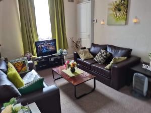 a living room with leather couches and a coffee table at Blue Lion Place in Edinburgh