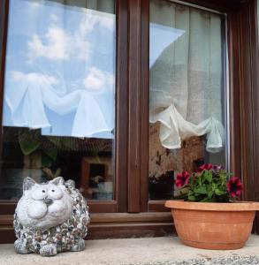 una estatua de un gato sentado frente a una ventana en C'era una volta, en Castelnuovo Don Bosco