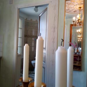 a group of white candles in front of a mirror at Appartement de Ville Médiévale in Vinça