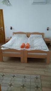 a bed in a room with two orange shoes on it at Szentmárton Vendégház in Tótszentmárton