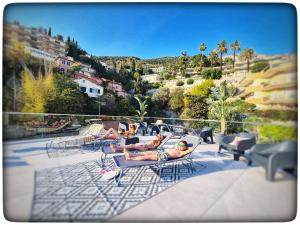 a group of people laying in chairs on a patio at Le Vallaya Suites & Spa in Menton