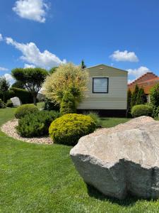 a house with a rock in front of a yard at Penzion Verde in Mikulov