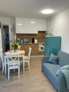 a living room with a couch and a table and a kitchen at IguHouse in Czaplinek