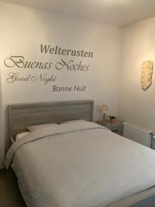 a bedroom with a bed with a sign on the wall at West-Ende in Middelkerke
