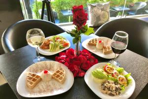 een tafel met borden en glazen wijn bij Destiny Hotel in Baños