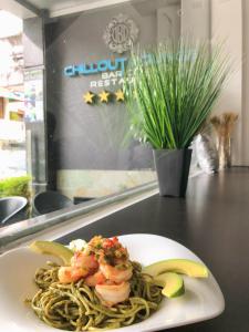 a plate of shrimp pasta and bananas on a counter at Destiny Hotel in Baños