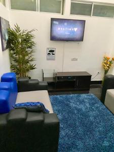 sala de estar con sofá y TV en la pared en Destiny Hotel, en Baños