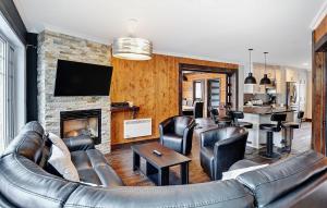 a living room with a leather couch and a fireplace at 08 Pied des Pentes in Stoneham