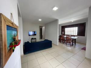 a living room with a blue couch and a dining room at casa brisa do mar in Aquiraz