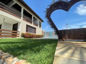 a building with a fence next to a grass yard at casa brisa do mar in Aquiraz