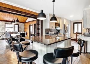 a kitchen with black chairs and a island in a room at 08 Pied des Pentes in Stoneham