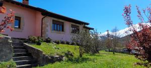 a house on a hill with mountains in the background at Mirador de Garabandal in San Sebastián de Garabandal
