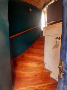 una scala in una piccola casa con una parete verde di La maison à la porte bleue a Voutezac Altre 4 foto