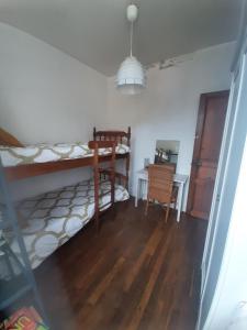 a bedroom with a bunk bed and a table and a desk at La maison à la porte bleue in Voutezac +3 photos