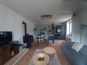 un soggiorno con un divano blu e un tavolo di La maison à la porte bleue a Voutezac