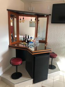 a bar in a room with a mirror and two stools at Hotel Pecato in Santa Rosa