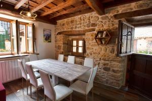 a dining room with a wooden table and chairs at Los Campos Vivienda Vacacional in Cangas de Onís