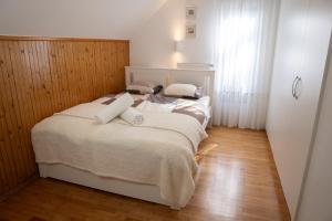1 dormitorio con 1 cama con sábanas y almohadas blancas en Chalet Lana with Hot Tub, en Gozd Martuljek