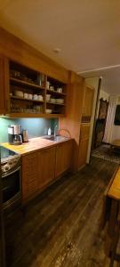 a kitchen with wooden cabinets and a stove top oven at Stöten Mitt Apartment, Sälen in Sälen