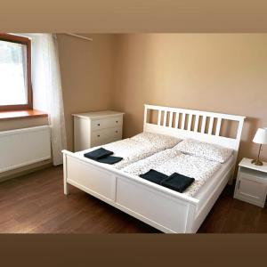 una camera da letto con un letto bianco con due tavoli e una finestra di Chalupa u lesa - Nova Ves a Český Rudolec Altre 30 foto