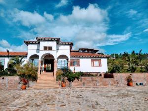 Biały dom ze schodami przed nim w obiekcie Hotel Campestre Cordillera de los Andes w mieście Villa de Leyva