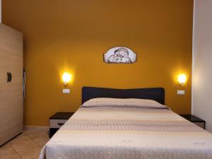 a bedroom with a bed and a yellow wall at B&B La Filanda in Scilla