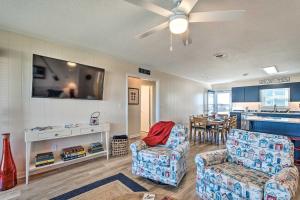 a living room with two chairs and a tv at Quaint Sand Dollar Sandbar - Walk to Beach! in Topsail Beach