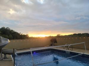 una piscina en el techo con la puesta de sol en el fondo en Deer Run Estate LLC, en Marshfield