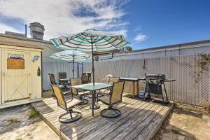 Wildwood Apartment - Porch and Enclosed Sunroom! في وايلدوود: فناء مع طاولة ومظلة وشواية