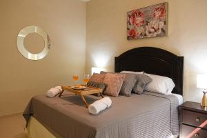 1 dormitorio con 1 cama con mesa y copas de vino en The Cozy Apartment, en San Salvador