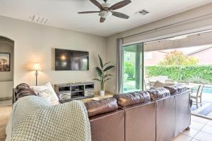 a living room with a leather couch and a television at Bright Phoenix Home with Private Pool and Hot Tub in Anthem