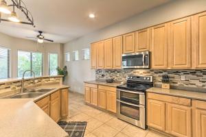 a kitchen with wooden cabinets and a stove top oven at Bright Phoenix Home with Private Pool and Hot Tub in Anthem