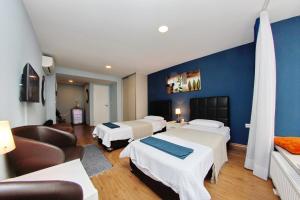 una habitación de hotel con tres camas y un sofá en Apartmani BarSa, en Sarajevo