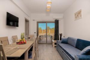 uma sala de estar com um sofá azul e uma sala de jantar em Villa En Elladi em Alikanás