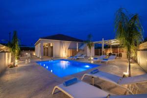 a swimming pool in a backyard at night at Villa En Elladi in Alikanas