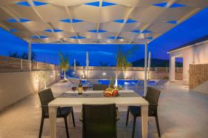 a patio with a white table and chairs and lights at Villa En Elladi in Alikanas