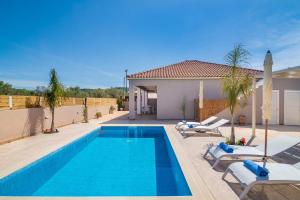 a swimming pool with lounge chairs and a house at Villa En Elladi in Alikanas
