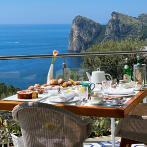 a table with food and a view of the ocean at Quattro Passi Relais in Nerano