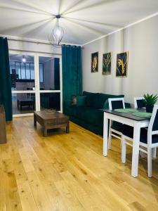 sala de estar con sofá verde y mesa en Apartament Odpoczynek en Ustrzyki Dolne
