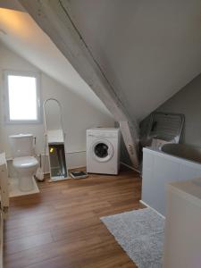 a bathroom with a washer and dryer in a attic at Grand T2 climatisé très calme in Périgueux